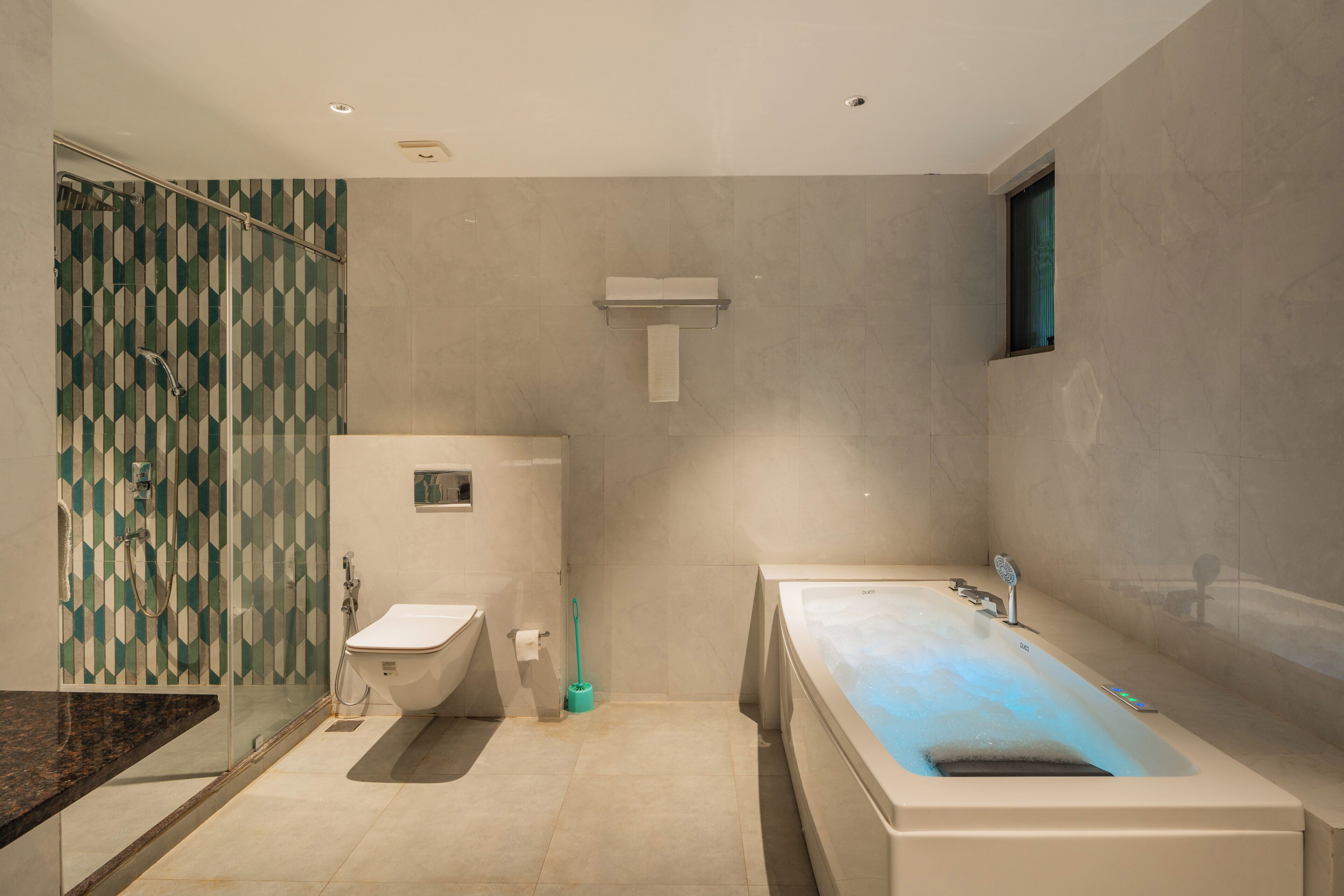 A modern bathroom with a bathtub, a shower, and a toilet.