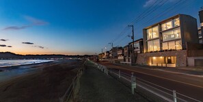 Una carretera costera con edificios modernos, una playa y un cielo despejado.