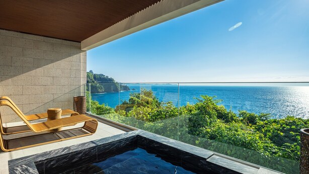 A balcony with a view of the sea, a hot tub, and wicker furniture. - UMITO ATAMI BETTEI (Atami)