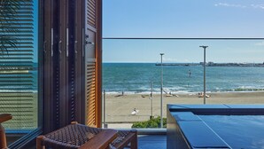 Een balkon met uitzicht op een strand en de zee.