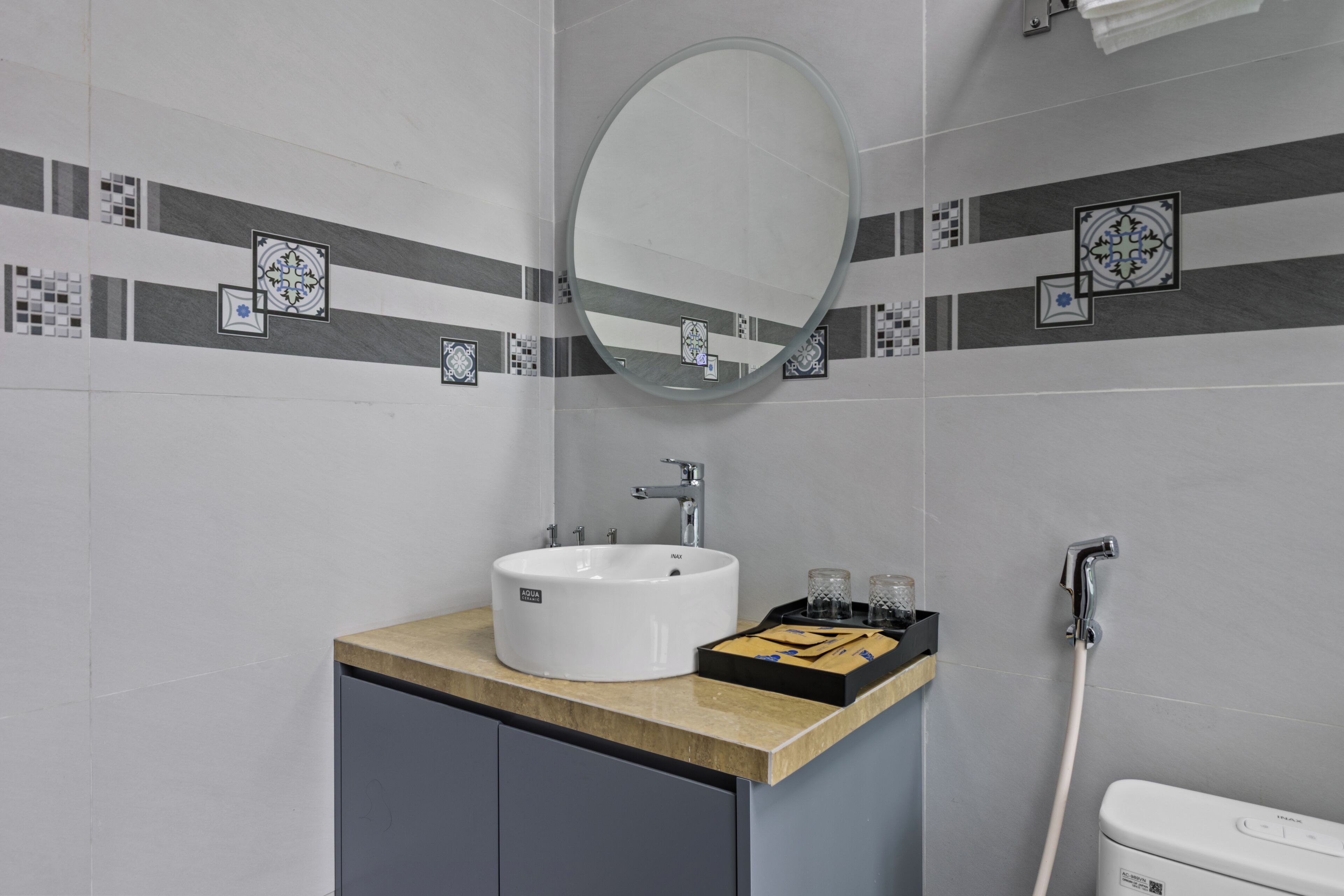 Un bagno con un lavandino bianco, uno specchio e una doccia.