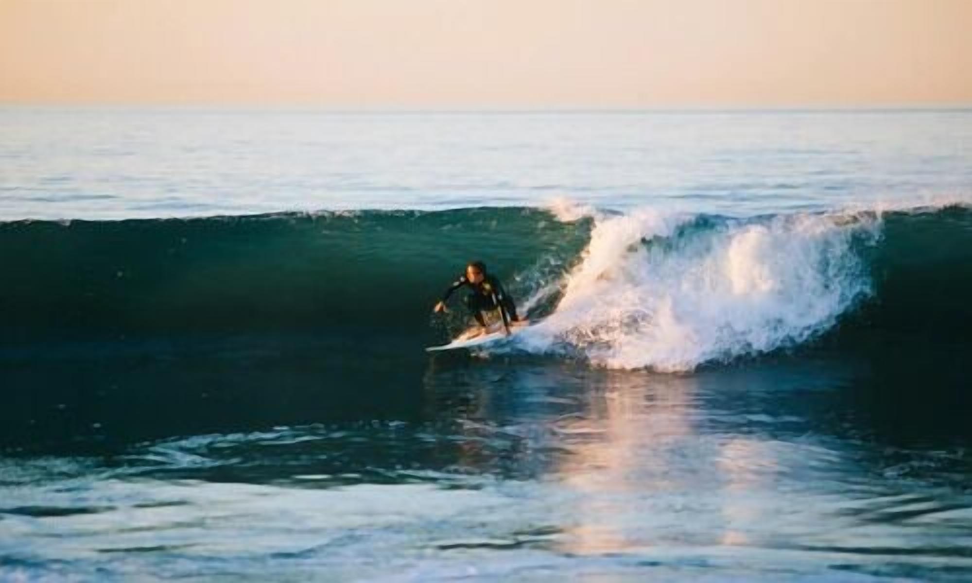 A surfer riding a wave in the ocean.