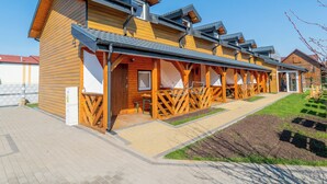 File di cabine di legno con una passerella coperta, ciascuna con finestra e porta.