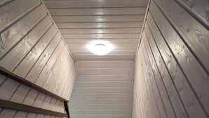 Una scala in legno con ringhiera metallica che conduce a una lampada a soffitto.