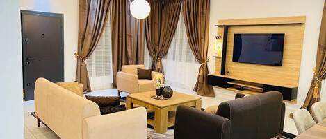 Suíte luxo, 3 quartos, serviço de arrumação, vista para a colina | Área de estar | Smart TV 32 polegadas com canais digitais