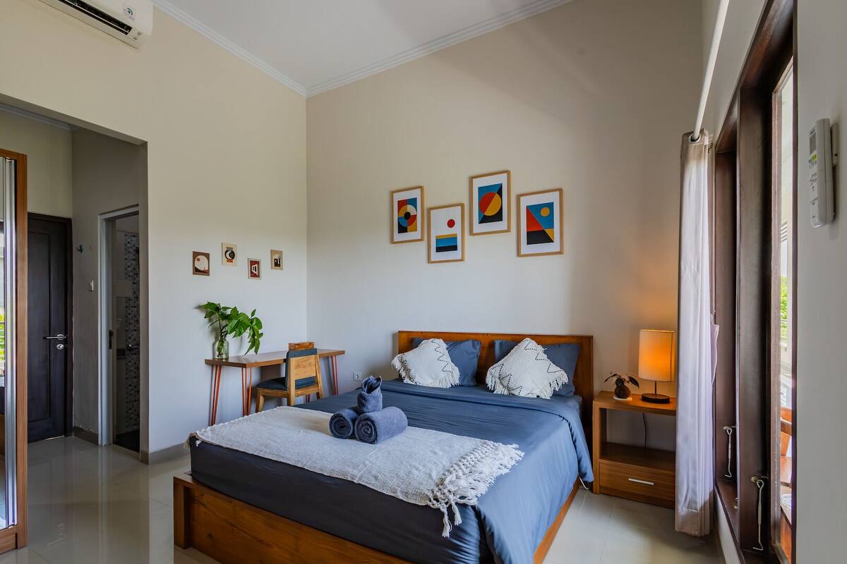 Une chambre à coucher avec un lit, des tables de chevet, un bureau et une chaise.