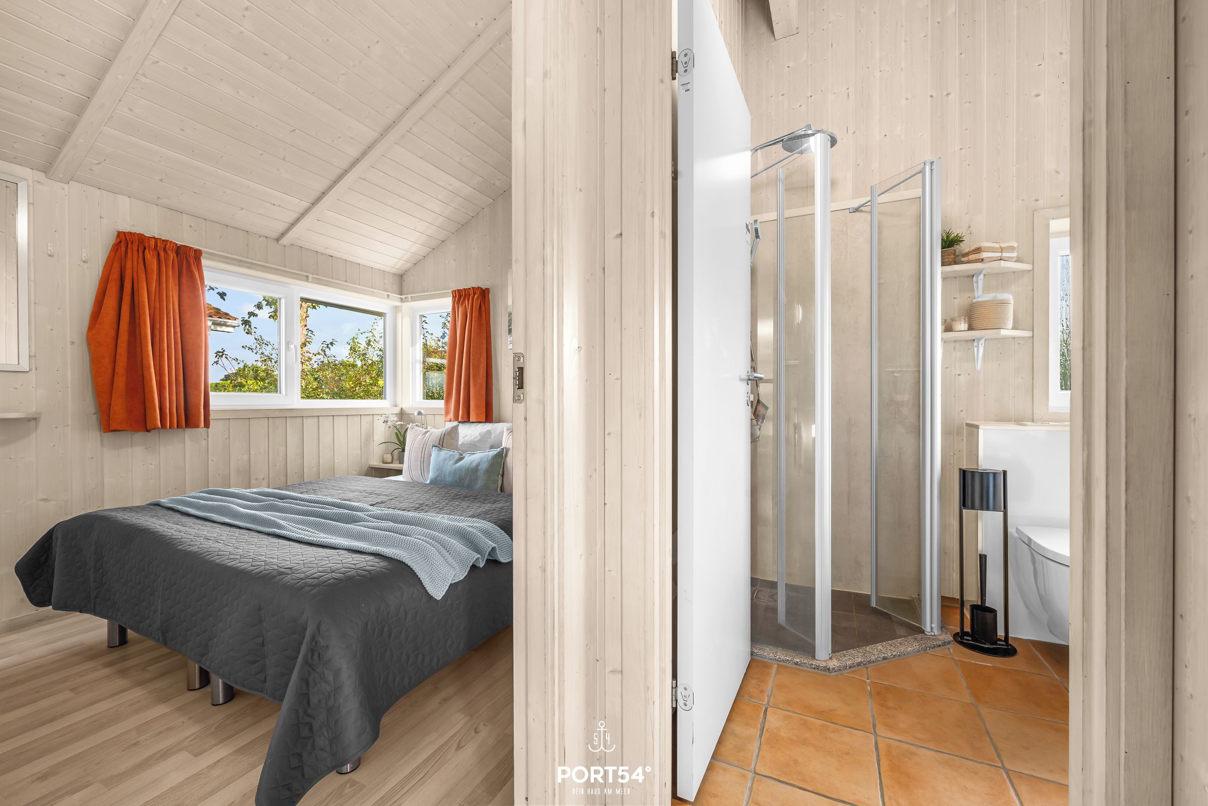 A bedroom with a bed, a shower, and a bathroom.