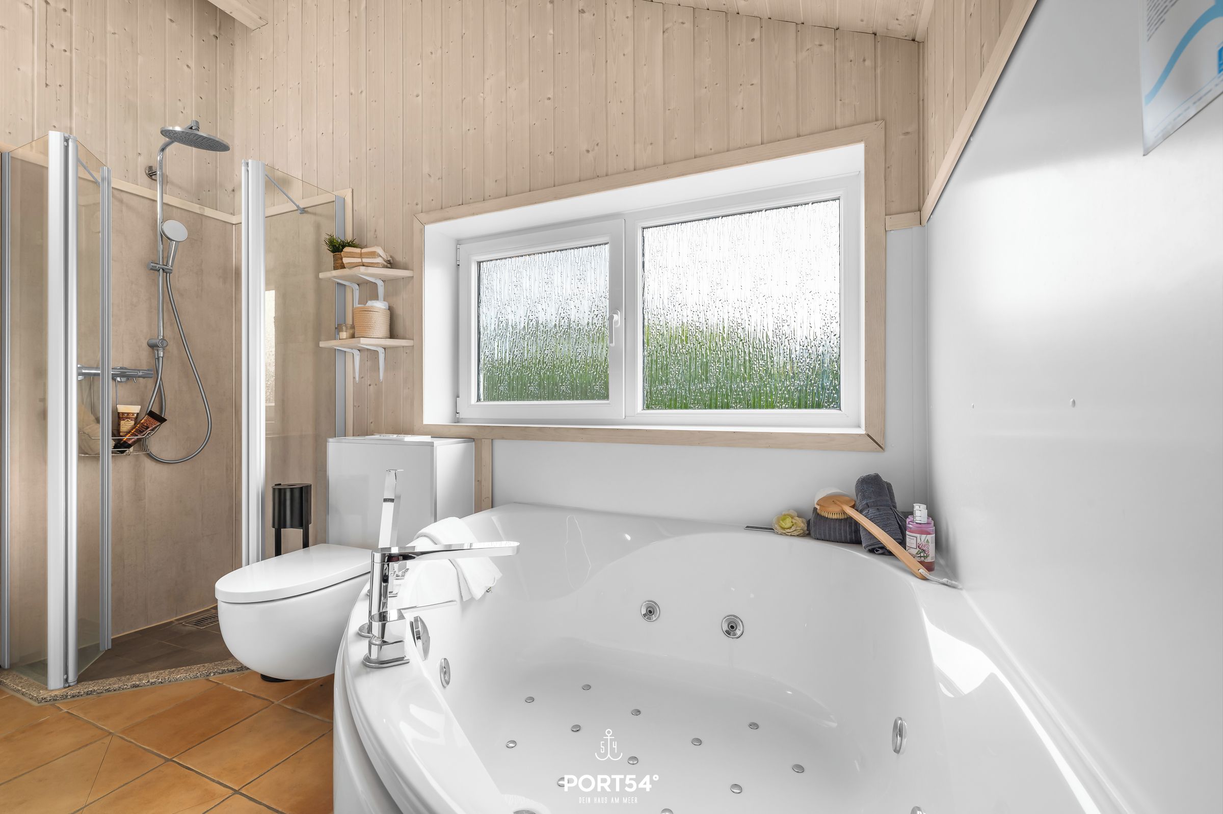 Ein modernes Badezimmer mit einer großen Badewanne, einer Duschkabine und einer Toilette.