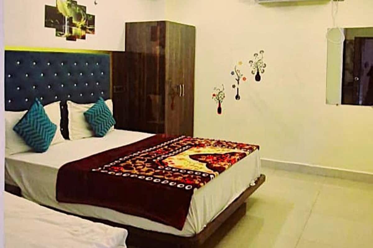 A modern bedroom with a large bed, a ceiling fan, and an air conditioning unit.