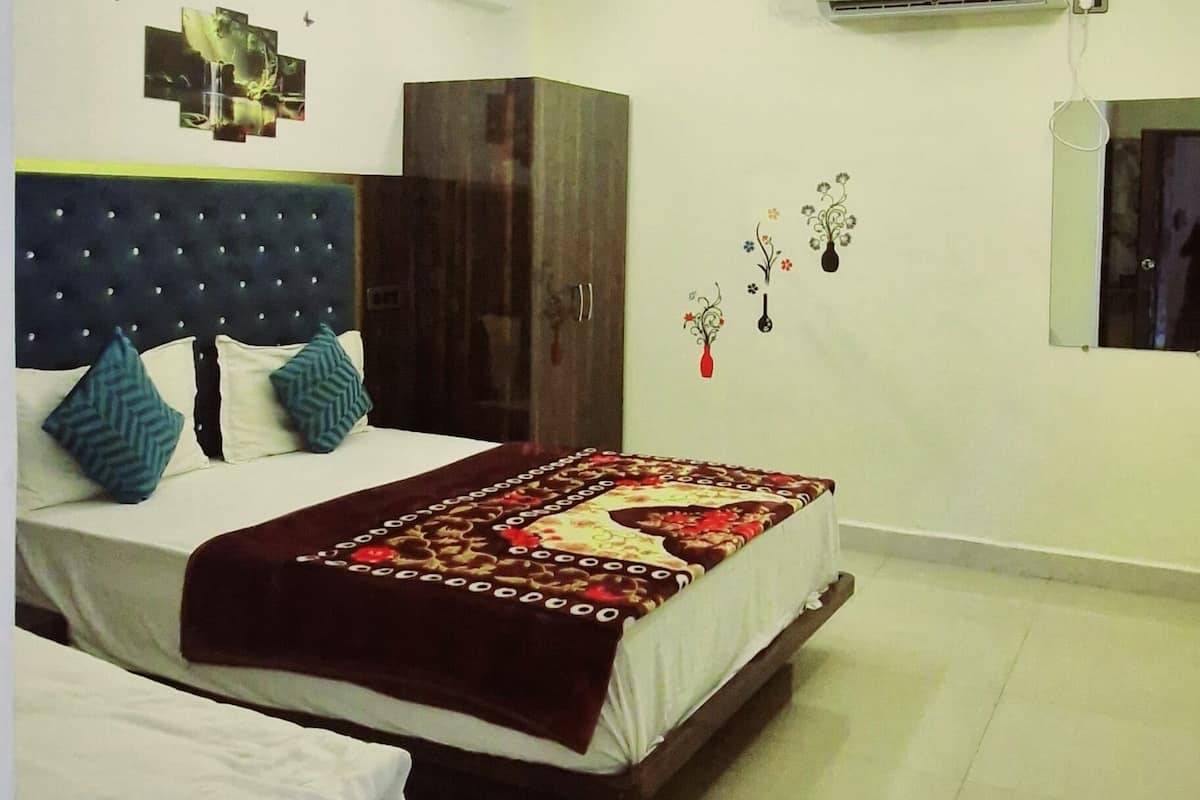 A modern hotel room with a large bed, a ceiling fan, and an air conditioning unit.