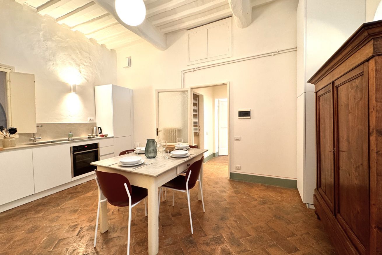 Una cucina con un tavolo da pranzo per quattro persone, un fornello e un frigorifero.