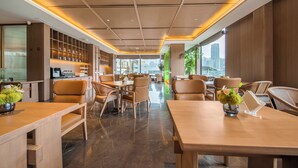 Een modern interieur met een keukenhoek, zithoek en grote ramen met uitzicht op de stad.