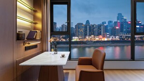 Een moderne hotelkamer met een groot raam en uitzicht op de stad.