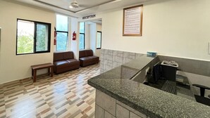 A reception area with a reception desk, a sofa, and a bench.