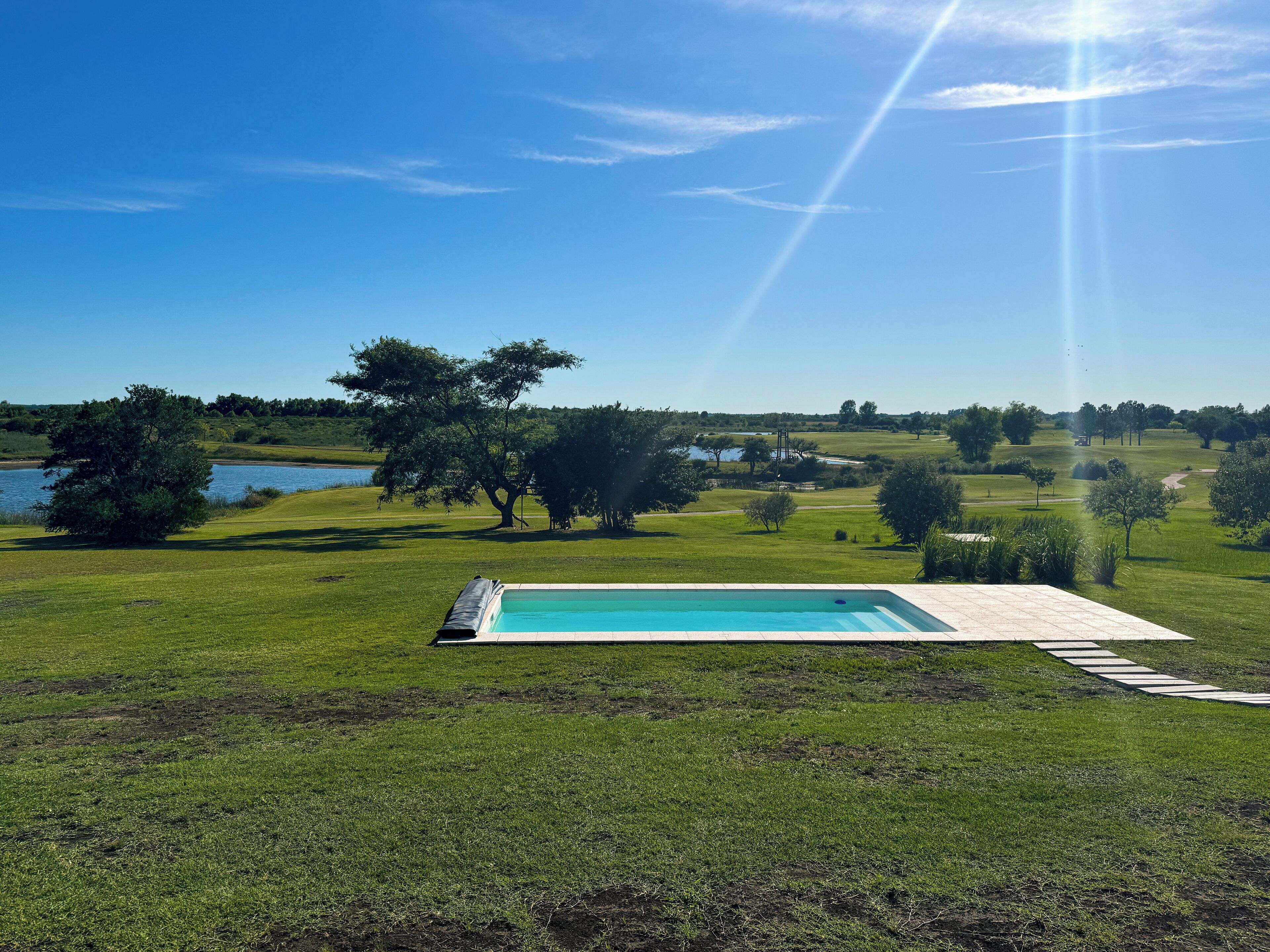 Una piscina al aire libre, sillones reclinables de piscina