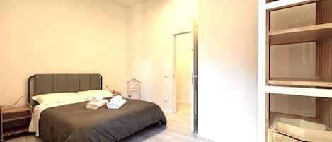 A bedroom with a bed, bedside table, and a wardrobe.