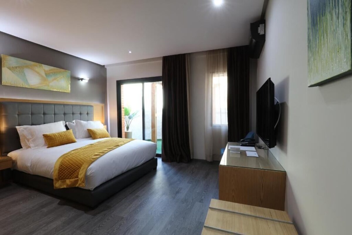Een moderne hotelkamer met een groot bed, een bureau en een televisie.