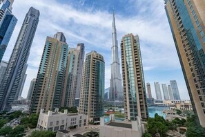 A cityscape with high-rise buildings, including a prominent skyscraper, and a body of water.
