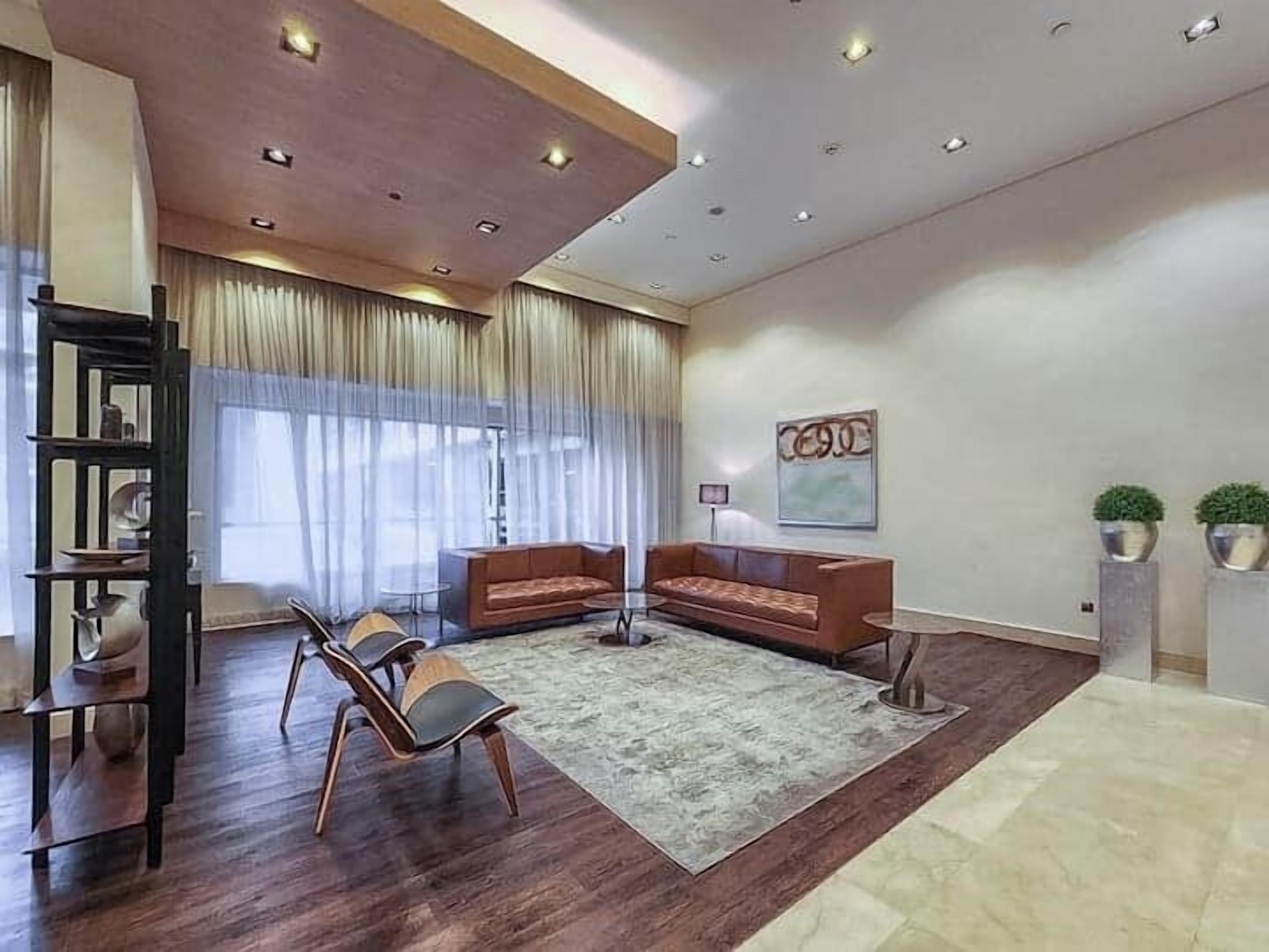 Un soggiorno moderno con soffitto in legno, due divani, un tavolino da caffè ed una libreria.