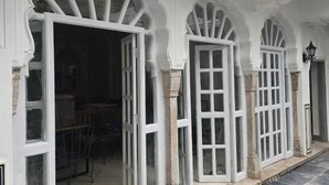Un bâtiment doté d’arches blanches et de portes ouvertes donnant sur un espace intérieur.