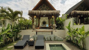 A resort with a thatched-roof structure, lounge chairs, a pool, and tropical plants. - Changi Jungle Ubud Villas (Ubud)