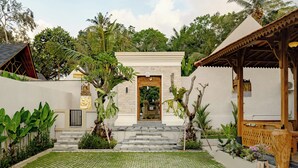 A courtyard with a central entrance, surrounded by plants and a tiled floor. - Changi Jungle Ubud Villas (Ubud)