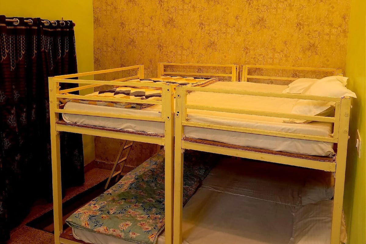 A bunk bed room with yellow walls and a patterned wallpaper.