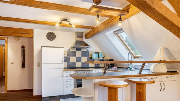 Une cuisine moderne avec un crédence à carreaux, un four encastré et une fenêtre au-dessus de l’évier.