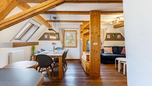 Une pièce de style loft comprenant un coin repas, un canapé et un plafond en bois.