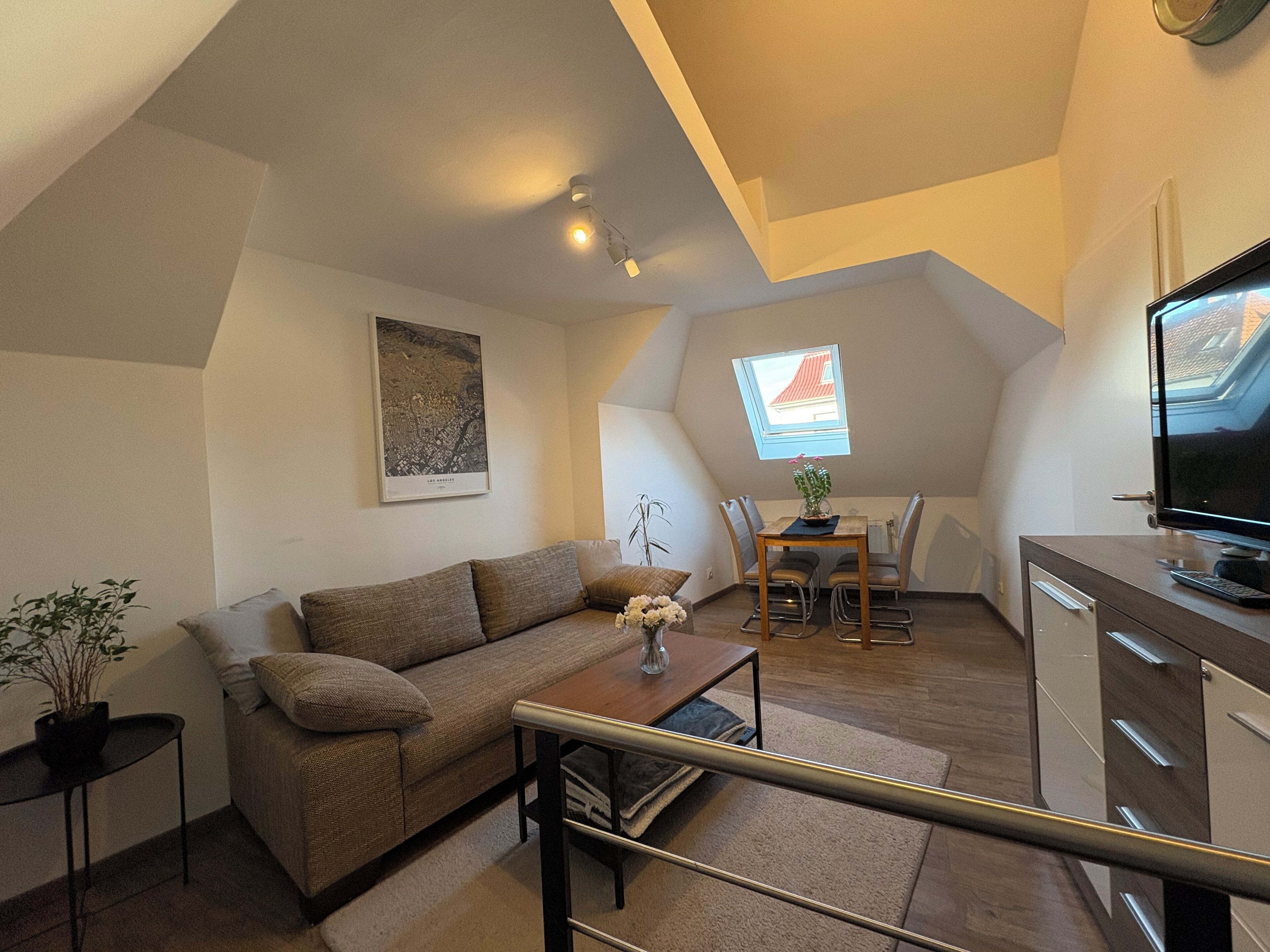 Een gezellig loft appartement met een hoogslaper, een eethoek, een televisie en uitzicht op de stad.