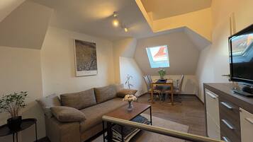 Een gezellig loft appartement met een hoogslaper, een eethoek, een televisie en uitzicht op de stad.