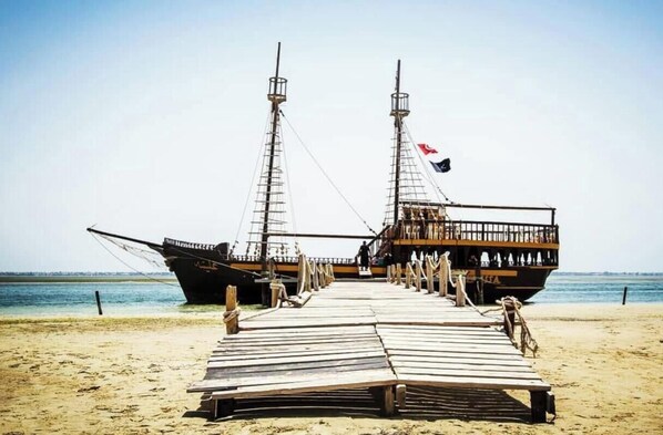 Two large ships docked on a sandy beach with a clear sky in the background. - Villa Lamys Djerba houmt souk with private pool (Houmt Souk)