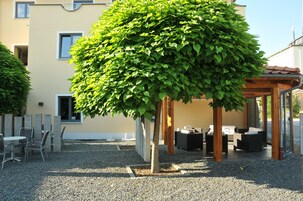 Un edificio con un patio que incluye asientos al aire libre y un jardín bien cuidado.