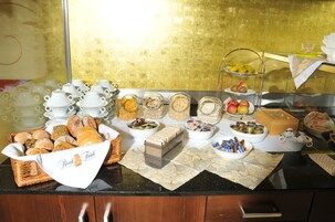 Un bufé con diversos alimentos, entre ellos pan, cereales y frutas.