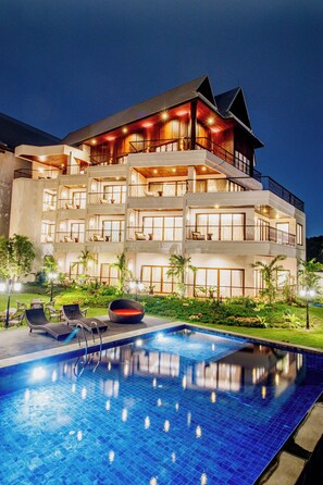 A multi-story hotel with a swimming pool, balconies, and outdoor seating. - S48 River Ping Hotel (Chiang Mai)