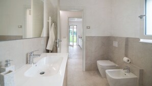 Un bagno moderno con un lavandino capiente, un bidet e un water.