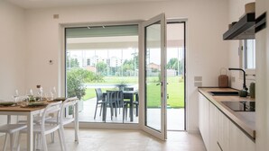Una cucina moderna con una porta vetrata scorrevole che dà su un patio.