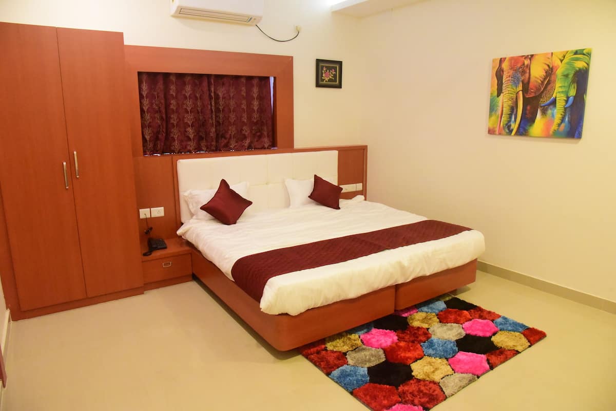 A bedroom with a bed, wardrobe, and a colorful rug.