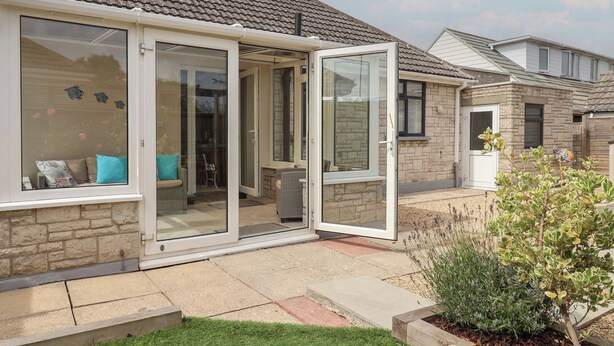 A residential property with a patio, a sliding glass door, and a brick exterior. - Cedar Drive (Weymouth)