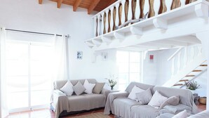 A spacious living room with a high ceiling and a staircase. - Ocean Whisper-spectacular villa on Portugal's west coast (Aljezur)