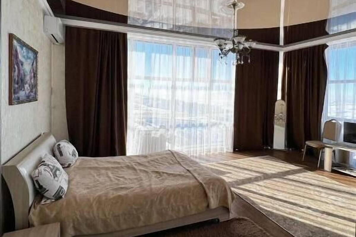Ein modernes Hotelzimmer mit einem großen Bett, einer Sitzecke und Blick auf die Stadt.