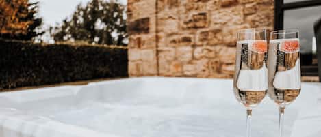 Two champagne flutes with a frothy head on a white hot tub.