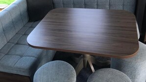 Ein gemütlicher Wohnbereich mit einem grauen Sofa, einem kleinen Holztisch und passenden grauen Sesseln.