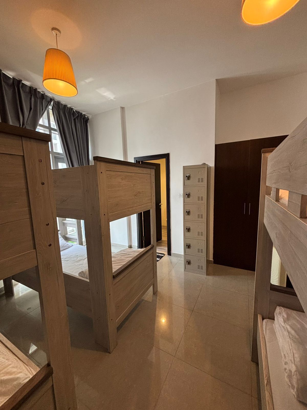 Une chambre avec des lits superposés, une armoire et un petit meuble de rangement.