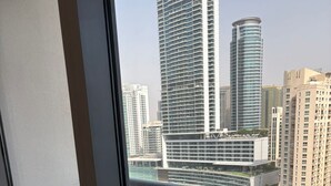 A balcony with a view of a marina, high-rise buildings, and a roundabout. - Lyo hostel Marina Whraf 1 (Dubai)