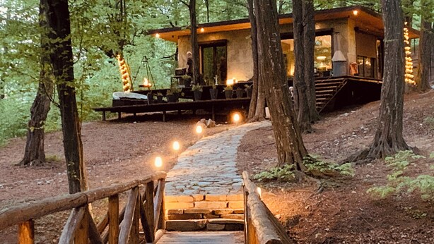 Un pont en bois menant à un chalet situé dans une forêt.