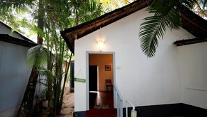 A white building with a red staircase leading to an interior room. - Temple Garden (Canacona)