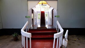 A staircase leading to a higher level with white railings and a red carpet. - Temple Garden (Canacona)