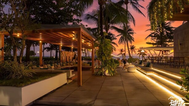 An outdoor seating area with a pergola, planters, and a view of the sunset. - V&T Hotel Phu Quoc (Phu Quoc)