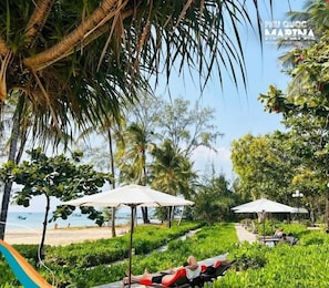 Rannalla, aurinkotuoleja, aurinkovarjoja, rantabaari